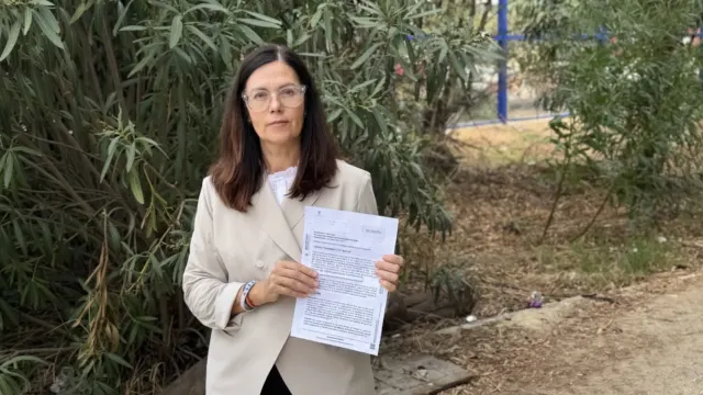 Isabel Pérez muestra el decreto del Ayuntamiento otorgando licencia para el cierre del acceso en Elviria